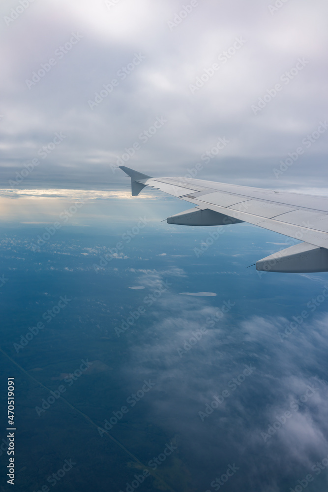 Fototapeta premium View from the airplane window at a beautiful blue sunrise and the airplane wing in clear sky.