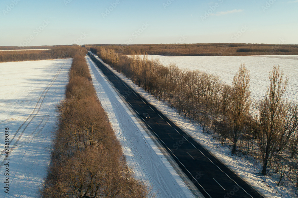 Construction of a new asphalt road in a winter forest