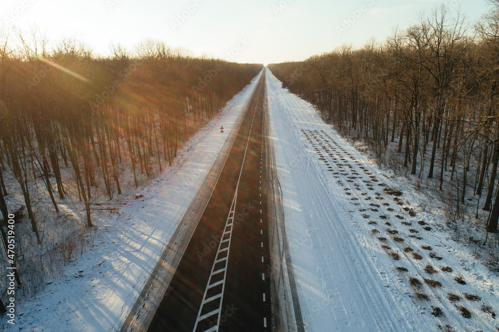 Obraz premium Construction of a new asphalt road in a winter forest