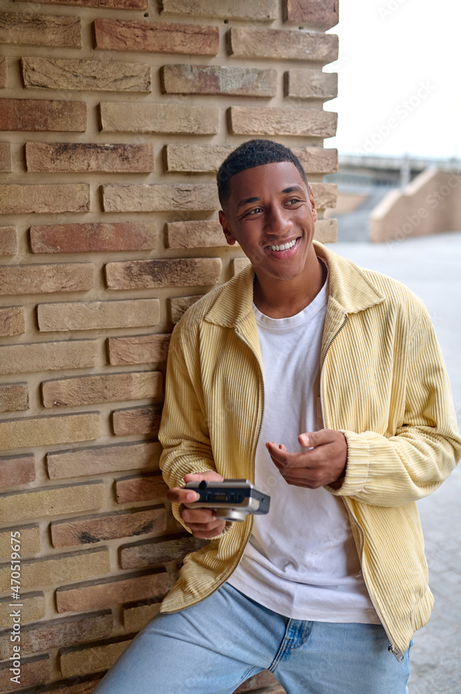 Smiling young male photographer feeling good and contented Smiling young male photographer feeling good and contented