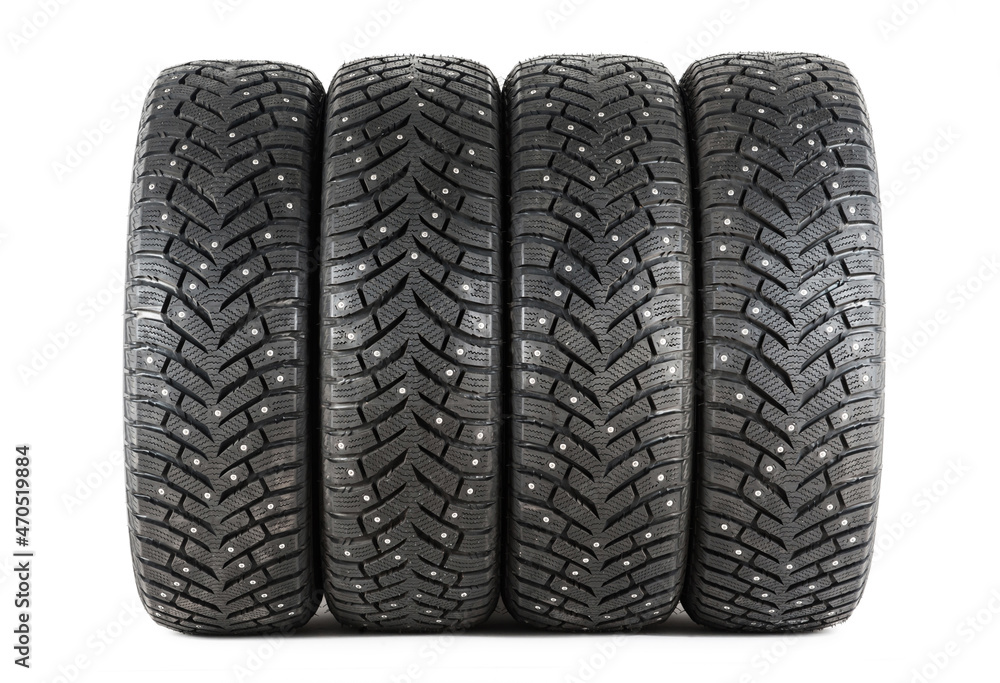 Four new winter car tires with spikes on a white background. Isolated Four new winter car tires with spikes on a white background. Isolated