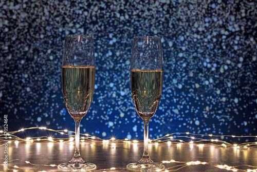 Champagne glasses surrounded by lights on a background of flashes