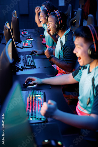 Fotografiet Competitive gamers playing and winning in online video game on high-powered game