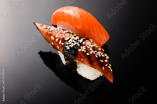sushi rolls with white rice, eel and sushi rolls with white rice and red salmon fish on a black background