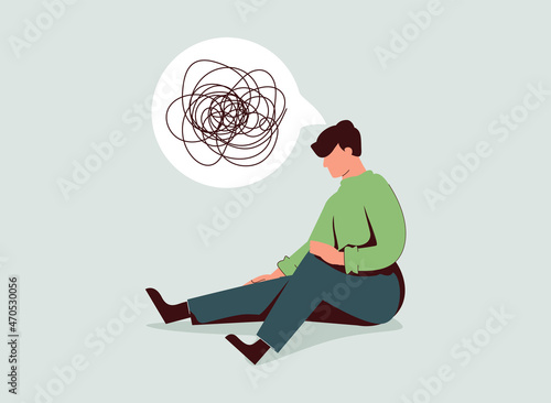 Sad man sits on the floor with tangled thoughts. The unhappy boy has confused thinking. The depressed male adolescent.