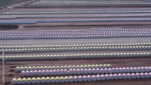 aerial ascending clip of rows of round cotton modules stored in a gin yard at trangie in western nsw, australia photo