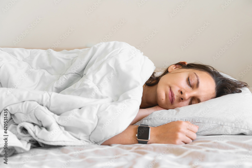 Young woman goes to sleep Phone addiction, insomnia. try to fall asleep. Sleep tracking on the phone and smart watch. Circadian rhythm. Young woman goes to sleep Phone addiction, insomnia. try to fall asleep. Sleep tracking on the phone and smart watch. Circadian rhythm.