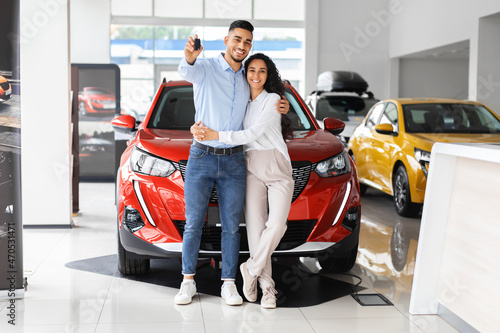 Фотография Happpy beautiful muslim family buying new car in salon