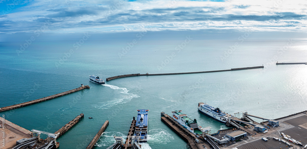 Obraz premium Aerial view of the Dover harbor with many ferries and cruise ships entering and exiting Dover, UK.