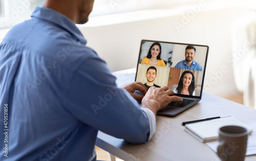 Cropped millennial caucasian guy have online meeting with different employees on laptop screen at workplace