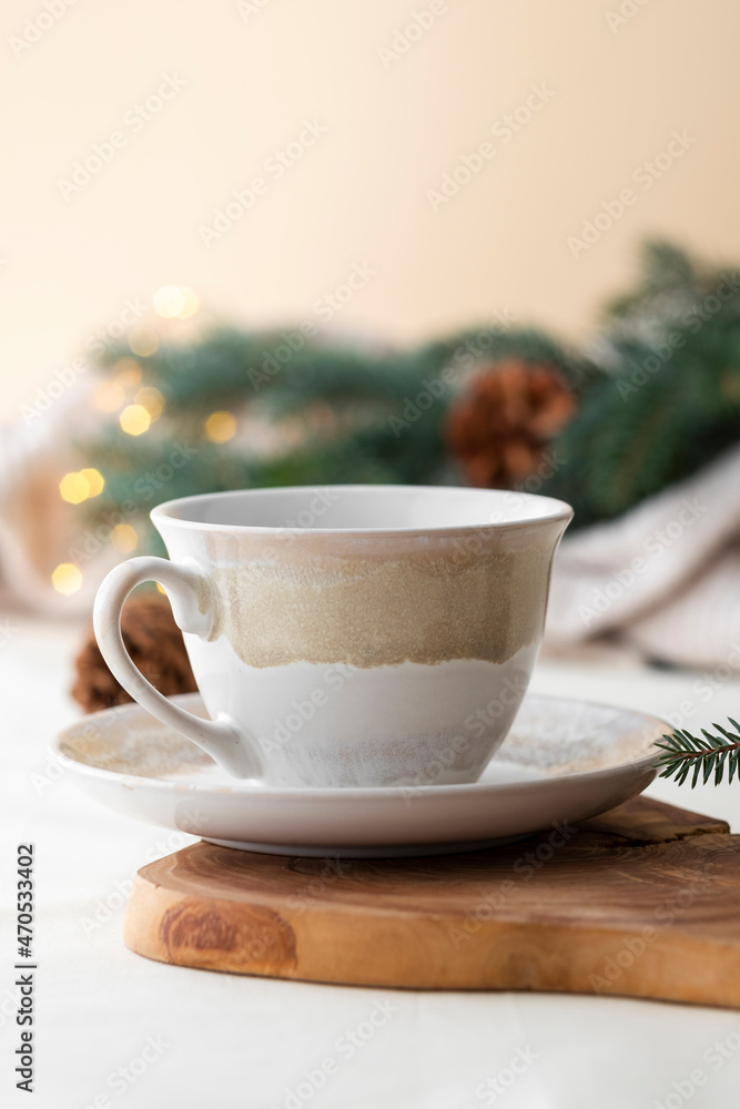 Fototapeta premium Tea cup with festive background of pine branches and pine cones. Christmas celebration.