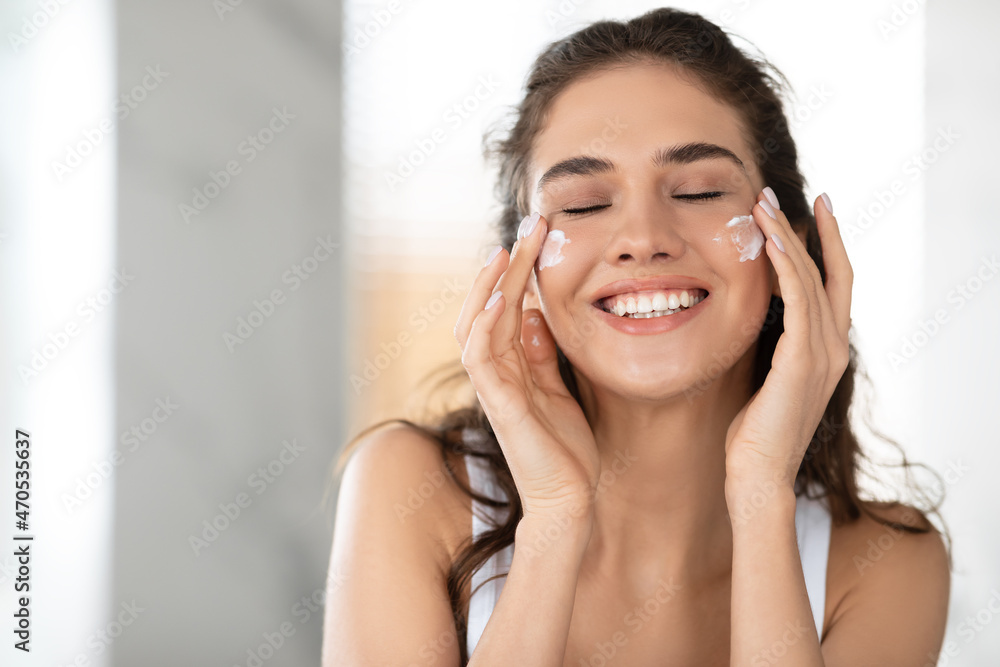 Lady Applying Facial Cream On Cheeks With Eyes Closed Indoor Lady Applying Facial Cream On Cheeks With Eyes Closed Indoor