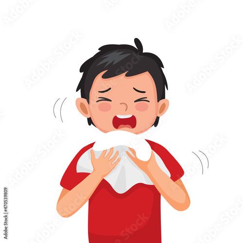 Cute little boy suffering from flu or cold allergy symptom sneezing on a handkerchief or tissue paper.
