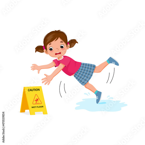 Cute little girl having accident slipping on wet floor and falling down near yellow caution sign.
