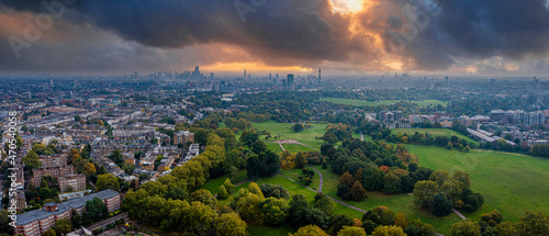 Fototapeta Naklejka Na Ścianę i Meble -  Beautiful aerial view of London with many green parks and city skyscrapers in the foreground.