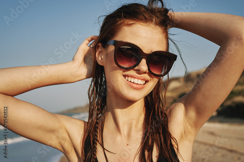 cheerful woman in sunglasses in a swimsuit on the beach sun island © VICHIZH