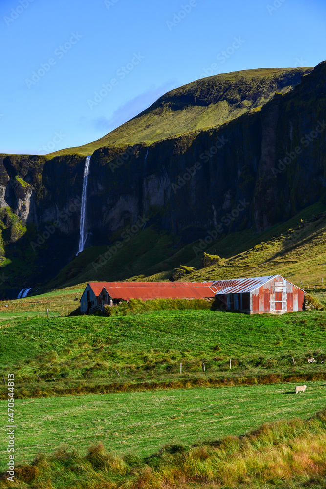 A barn on a farm and the Foss á Síðu waterfall as seen from the Ring Road (Route One), near the village of Kirkjubaejarklaustur, south coast of Iceland