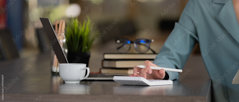 Close up businesswoman using calculator for analysis maketing plan, Accountant calculate financial report, computer with graph chart. Business, Finance and Accounting concepts