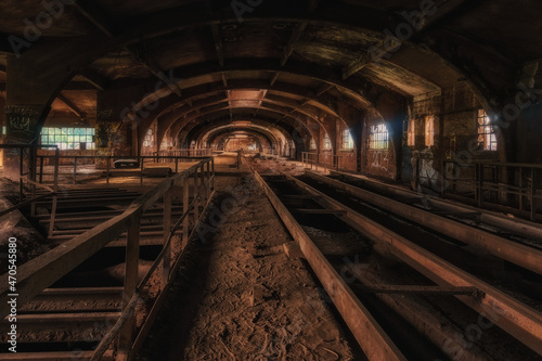 Dark industrial interior of an old abandoned long hall made of steel with dust on the ground, Luxembourg