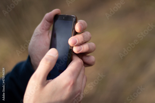 Smartphone in hand. The guy is on the phone. Communication device. Search for information.