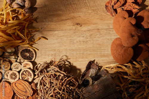 Obraz na plátně Traditional chinese medicine with herb and spices in brown wooden background and