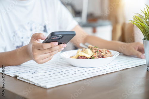 Crop image of hand using smartphone while eating at home, Hand Selective Focus.