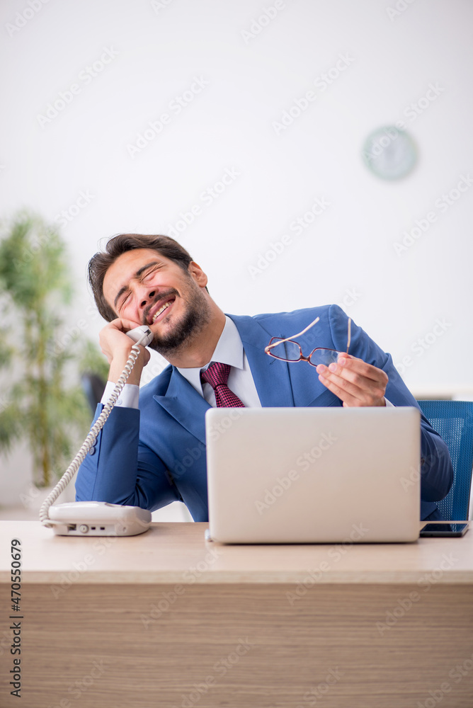 Young male employee sitting at workplace Young male employee sitting at workplace