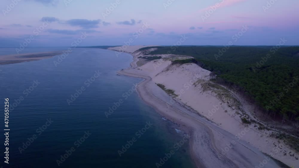 Evening seascape of a sand dune bordering a forest woodland in France travel destination Evening seascape of a sand dune bordering a forest woodland in France travel destination