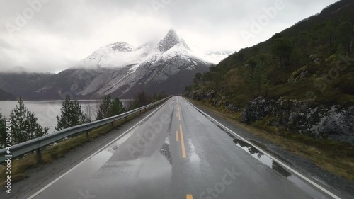 Wet Arctic road in direction of snow-covered Stetind mountain, Tysfjord, Norway photo