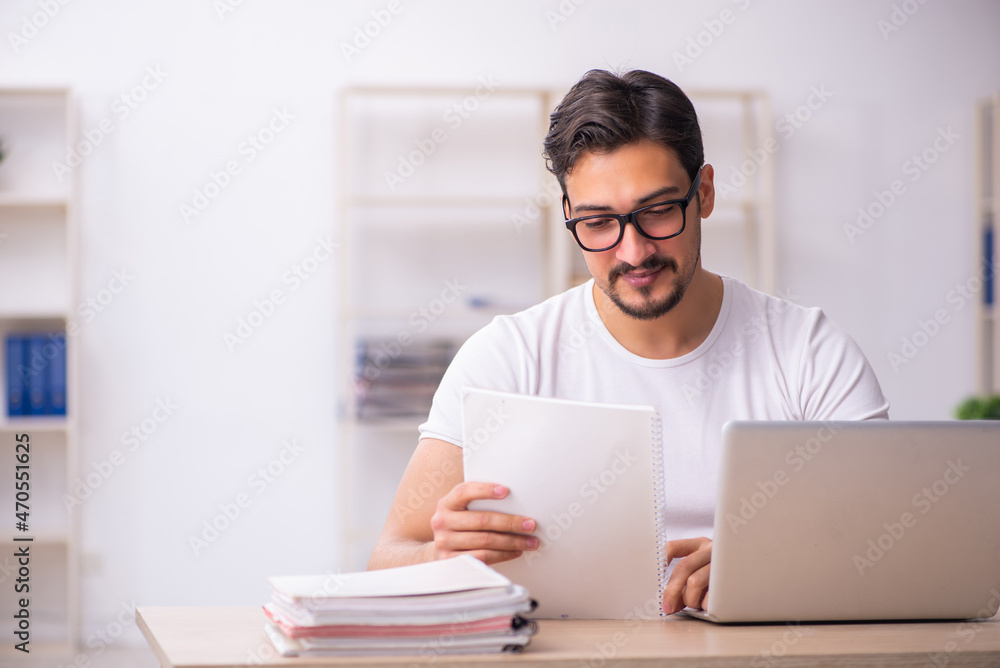 Young male student employee at workplace Young male student employee at workplace