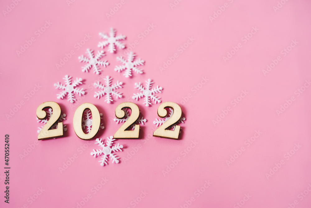 Pink pastel flatlay with snowflakes and wooden eco-friendly Christmas and New Year 2022 decorations Pink pastel flatlay with snowflakes and wooden eco-friendly Christmas and New Year 2022 decorations