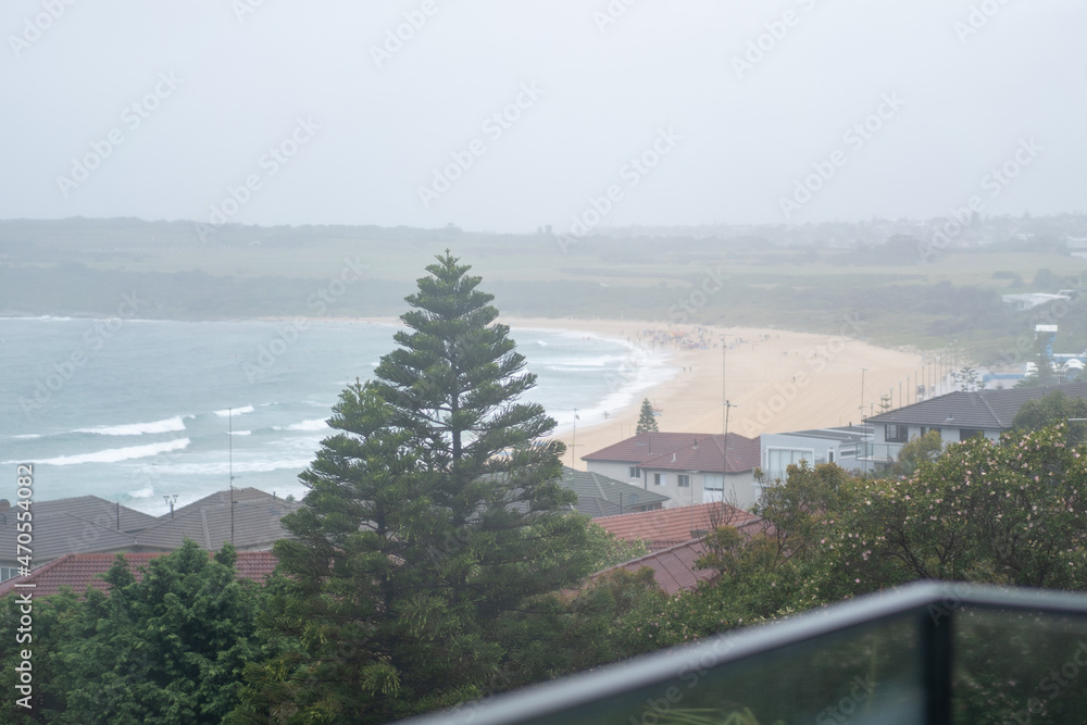 Blurred rain drops and beach through glass