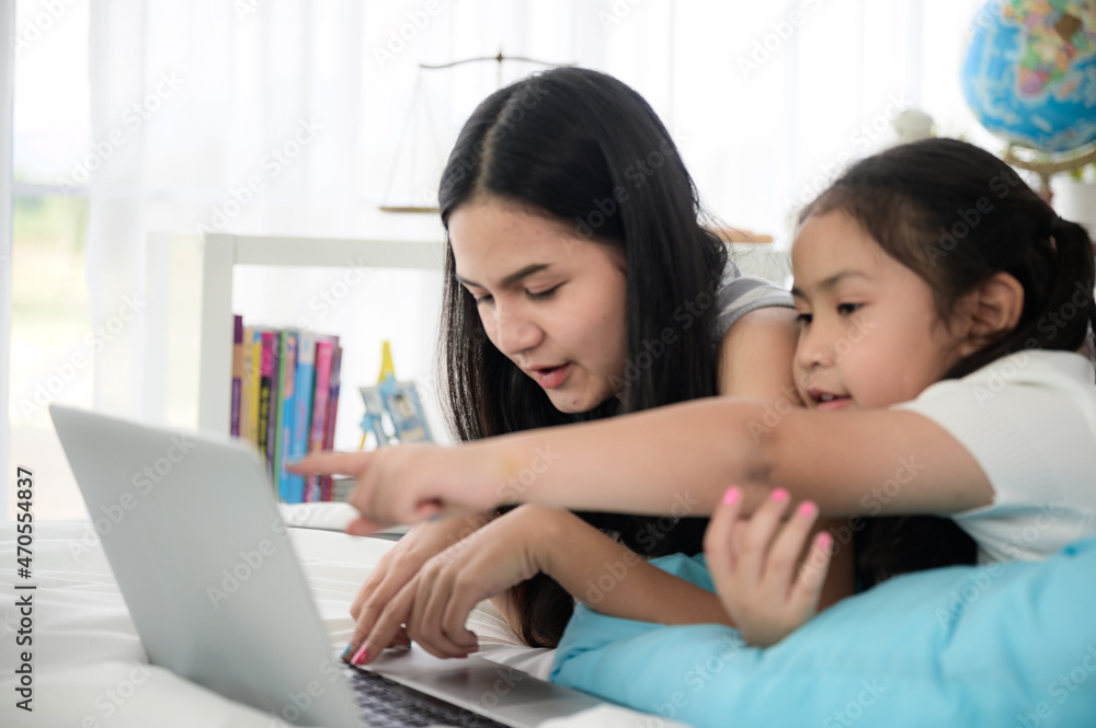 child girl person 2 sisters watching media and learning on laptop, online communication at home child girl person 2 sisters watching media and learning on laptop, online communication at home