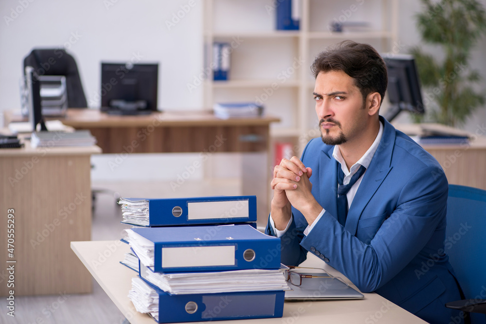 Young businessman employee unhappy with excessive work in the of Young businessman employee unhappy with excessive work in the of