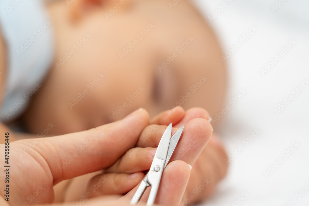 Cutting nails of a sleeping baby. Mom cuts the fingernails of her newborn  daughter while sleeping, close-up. Selective focus Stock Photo | Adobe Stock