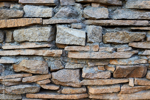 Natural stone masonry wall or fence concept background texture