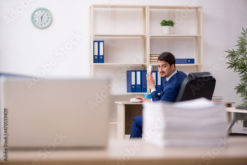 Young male employee and too much work in the office © Elnur