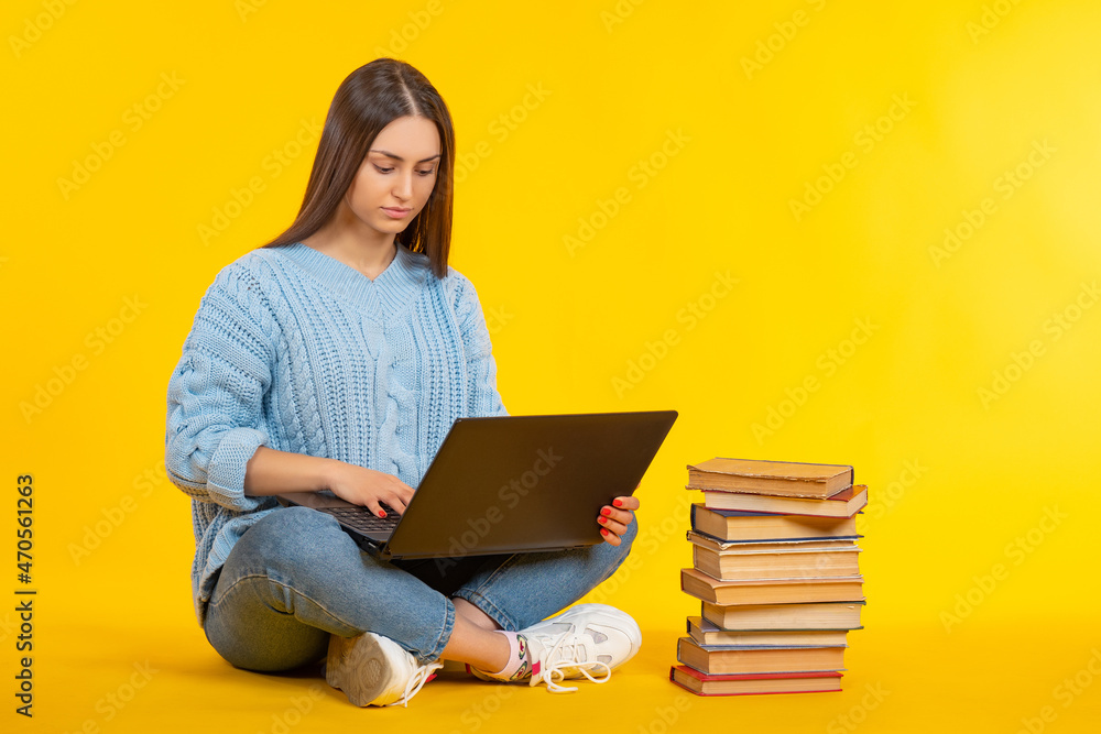 Female student with laptop on her lap. College student sportsret. Girl student in casual clothes. Young woman with stack of books. Getting independent education. Girl preparing for exam Female student with laptop on her lap. College student sportsret. Girl student in casual clothes. Young woman with stack of books. Getting independent education. Girl preparing for exam