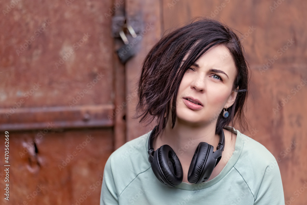 Fototapeta premium Portrait of a pretty girl with headphones around her neck
