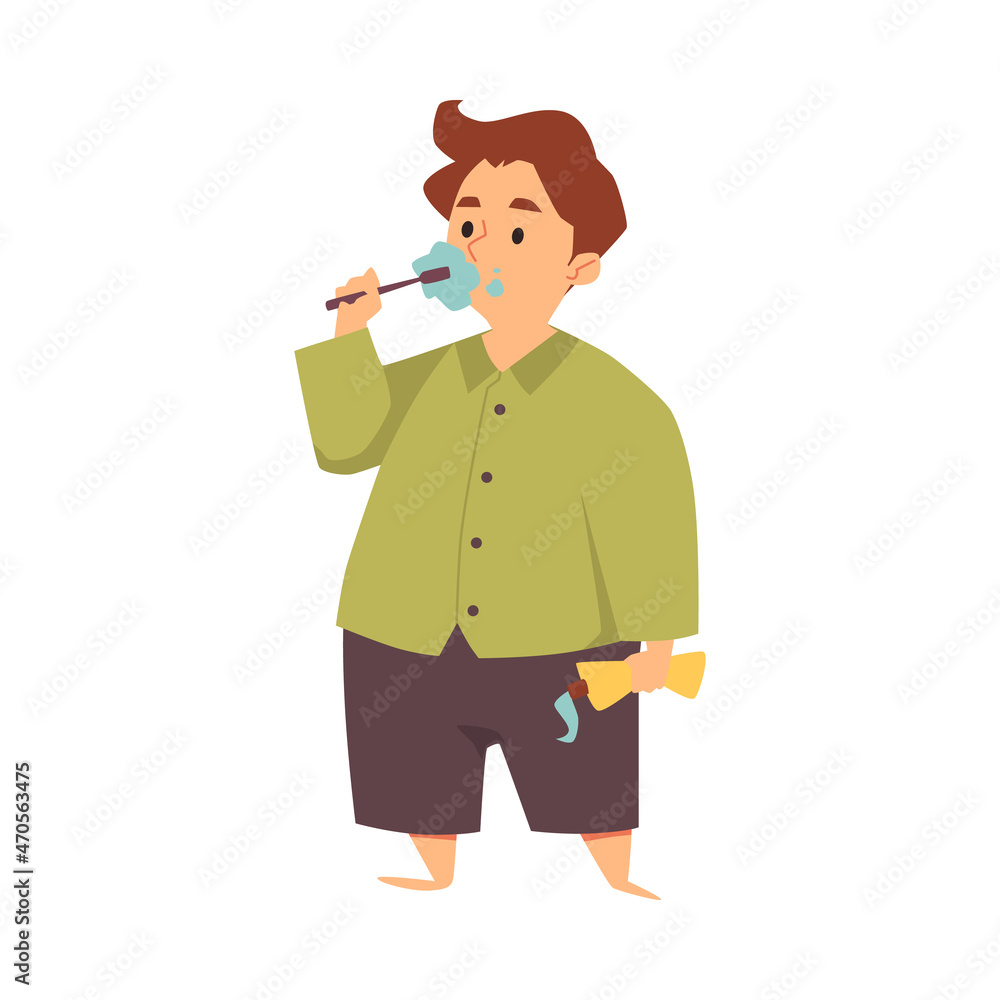 Kid boy in pajamas brushes teeth with tooth brush holding toothpaste in flat Kid boy in pajamas brushes teeth with tooth brush holding toothpaste in flat