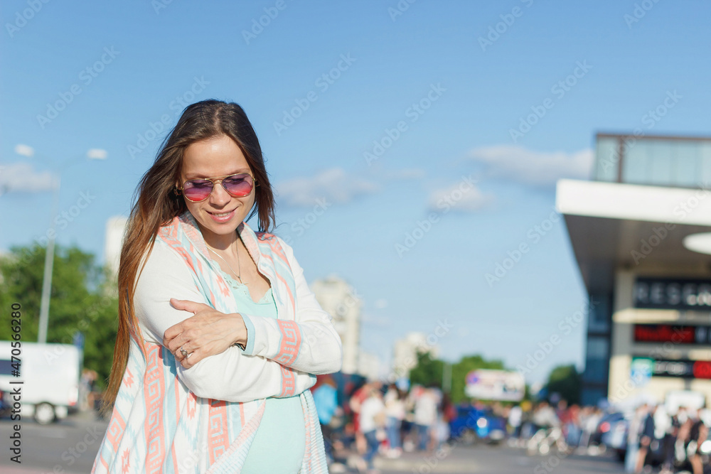 Pregnant woman is walking on the street of the city