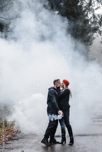 couple kissing in the fog. lovers tenderness colored smoke steam white on the path forest romance stylish passionate