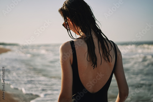woman in black swimsuit walking on the beach ocean summer
