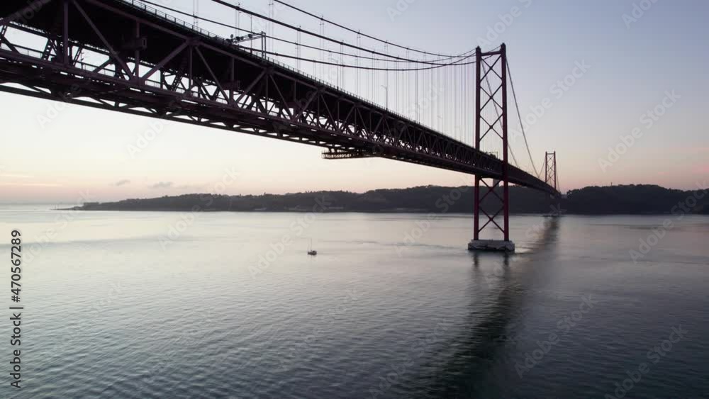 Small boat underneath the suspension bridge in Portugal. Small boat underneath the suspension bridge in Portugal.