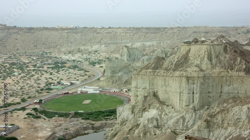 Cricket Oval Surrounded By Mountains And Rugged Landscape, Pakistan photo