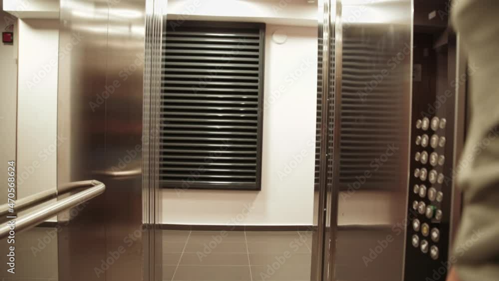 Woman exit from elevator into hotel corridor when doors are open Woman exit from elevator into hotel corridor when doors are open