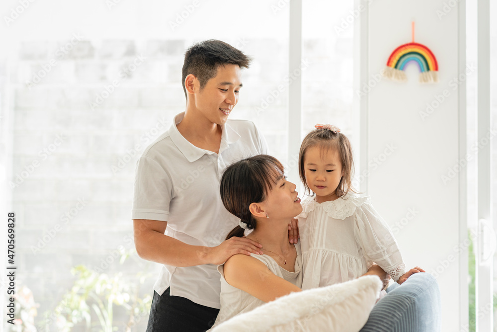 HERMOSA FAMILIA ASIÁTICA FELICES SENTADOS EN EL SOFÁ DE SU HOGAR CON UN ARCOIRIS EN LA PARED HERMOSA FAMILIA ASIÁTICA FELICES SENTADOS EN EL SOFÁ DE SU HOGAR CON UN ARCOIRIS EN LA PARED