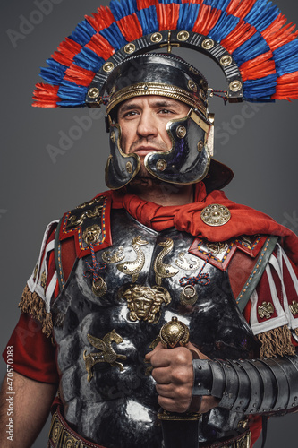 Thoughtful roman warrior dressed in steel armor and red cloak