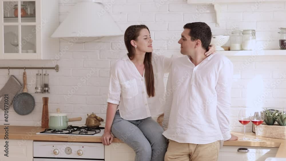 Young loving couple talking and smiling, hugging while standing in home kitchen room spbi. Beautiful Caucasian woman, man look with smiles and talk, hug and stand in light interior. 4k video Happy Young loving couple talking and smiling, hugging while standing in home kitchen room spbi. Beautiful Caucasian woman, man look with smiles and talk, hug and stand in light interior. 4k video Happy