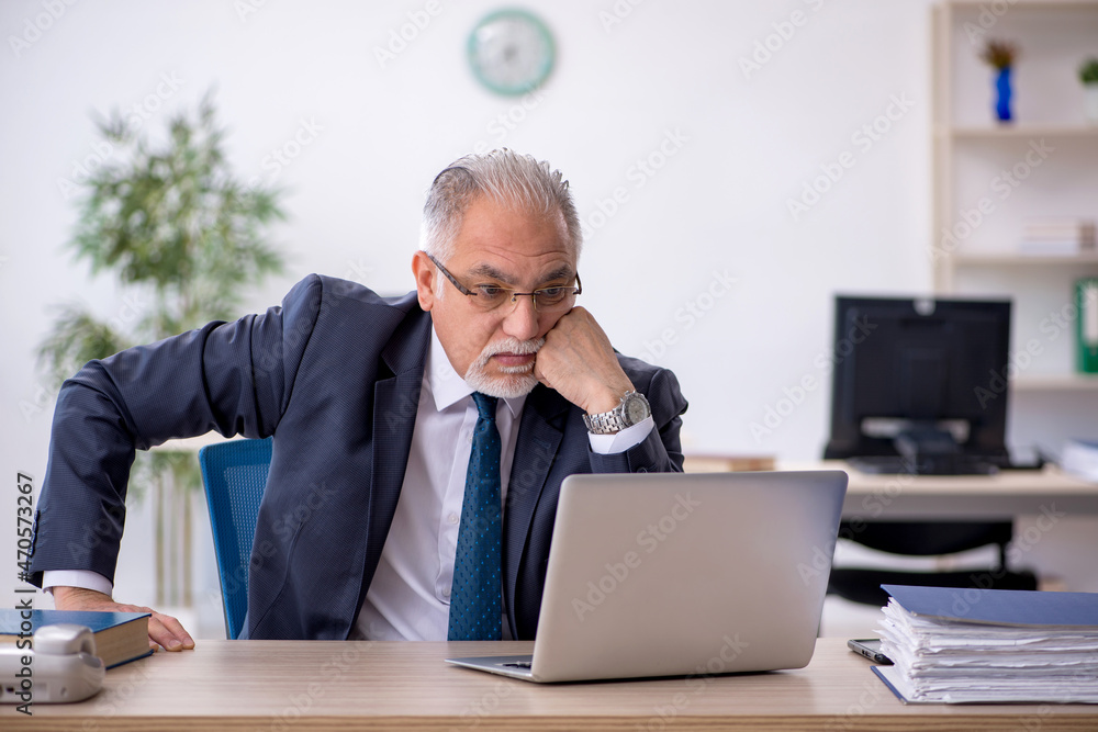 Old male employee working in the office Old male employee working in the office